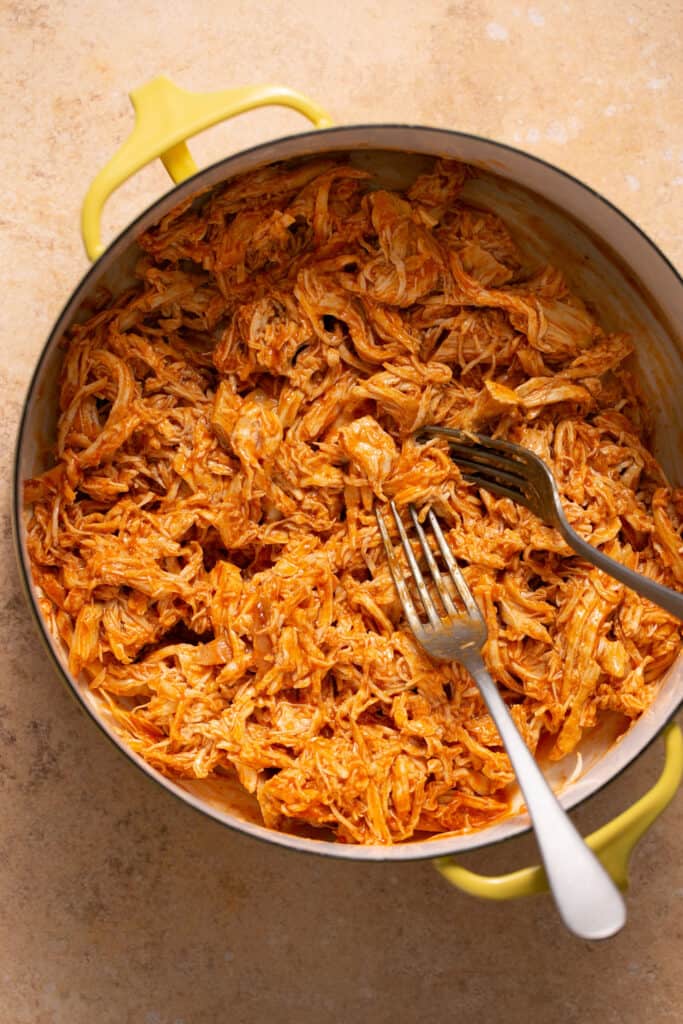 Cooked pulled buffalo chicken in a pot.