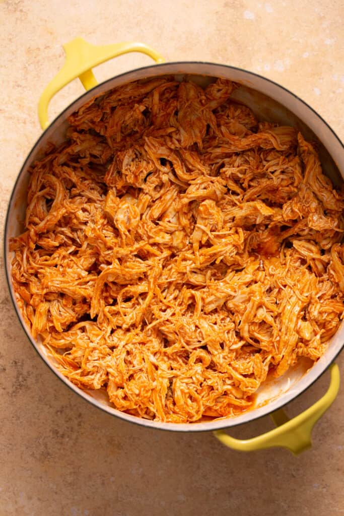 Cooked pulled buffalo chicken in a pot.