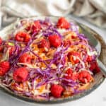 Healthy Ruby Red Raspberry Coleslaw in serving bowl with spoon.
