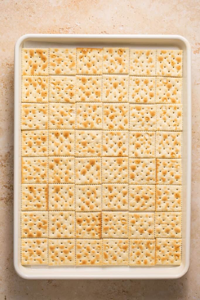 A single layer of crackers on a baking sheet.