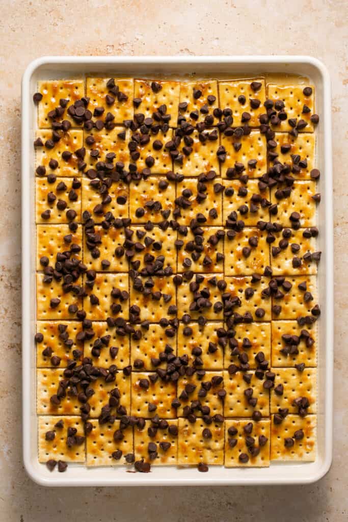 Chocolate chips on top of crackers topped with toffee.