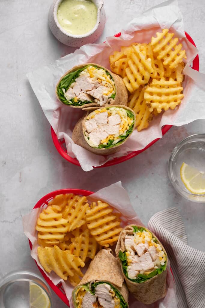 Chick fil a grilled chicken cool wrap in baskets with a side of fries.