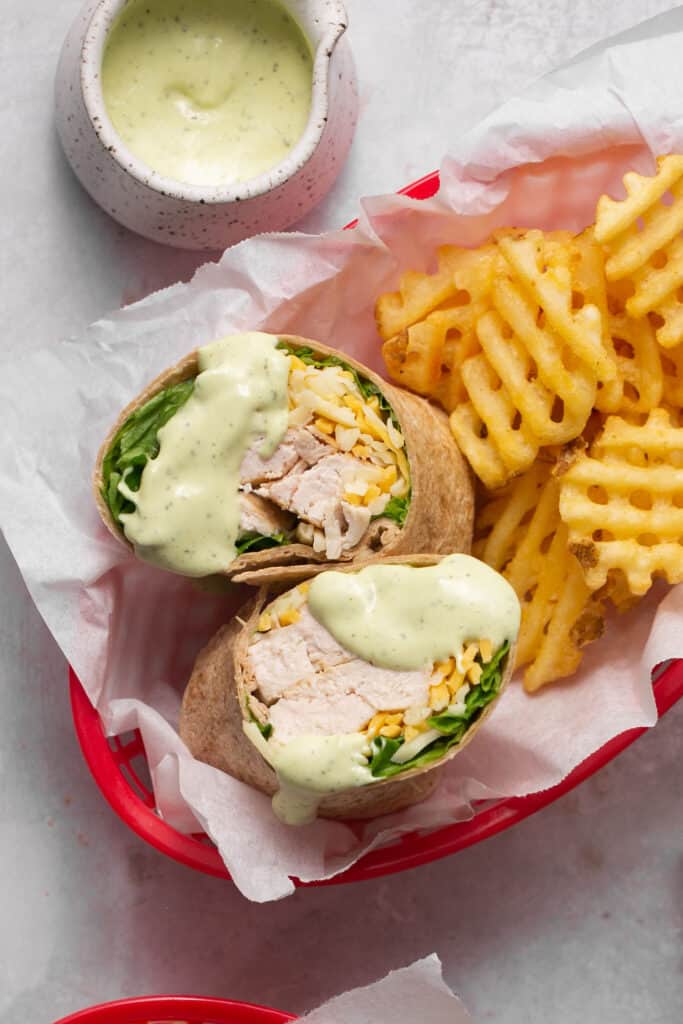 Chick fil a grilled chicken cool wrap in a basket with a side of fries.