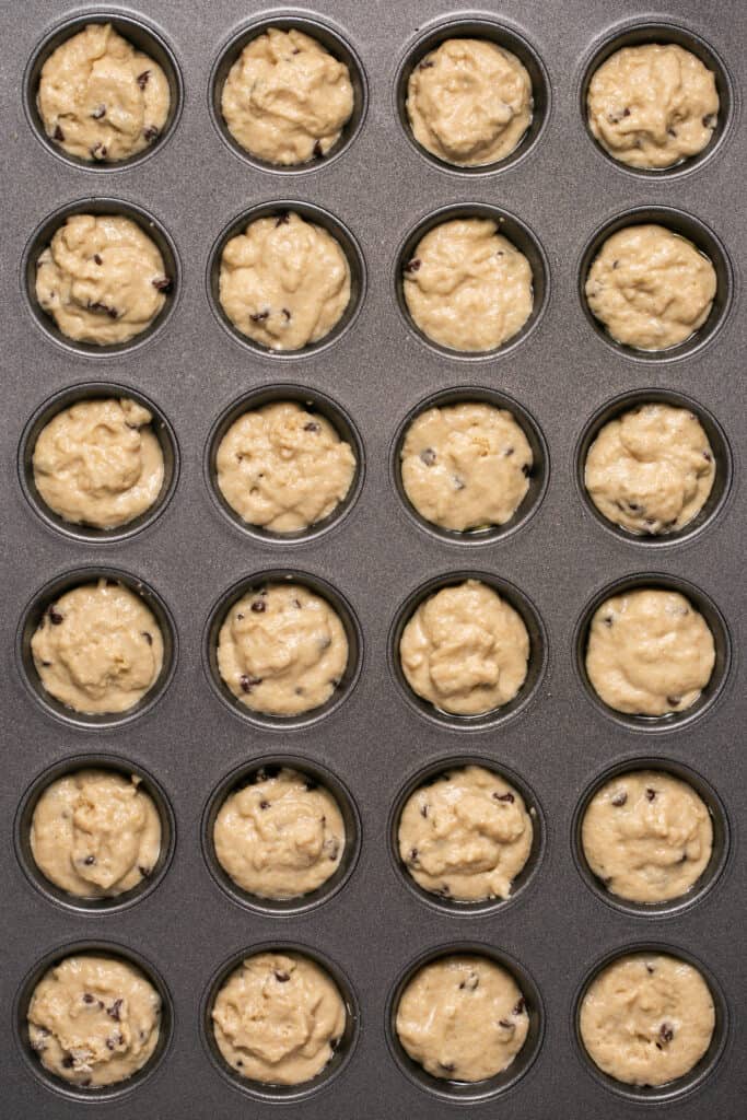 Mini chocolate chip pancake bites in a mini muffin tin before being baked.