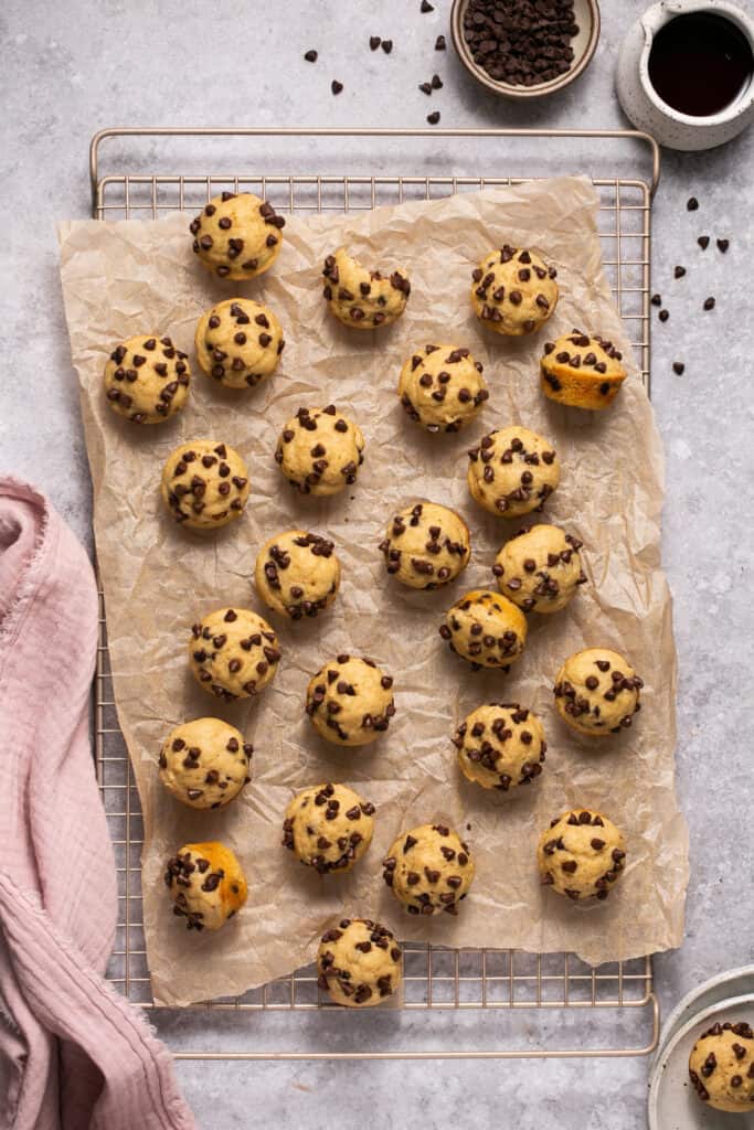 Mini chocolate chip pancake bites on a cooling rack with parchment paper.