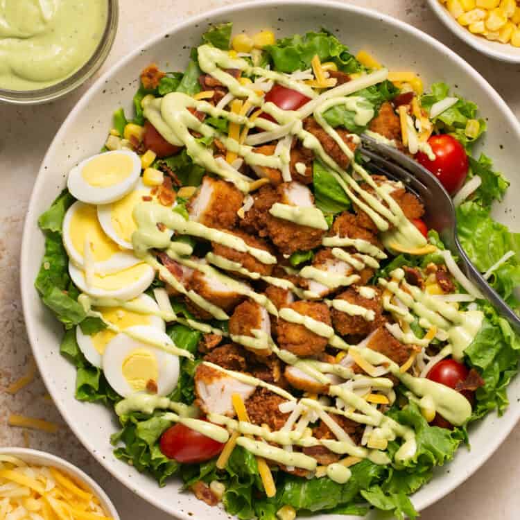 Chick-fil-a cobb salad recipe in a bowl topped with avocado lime dressing.