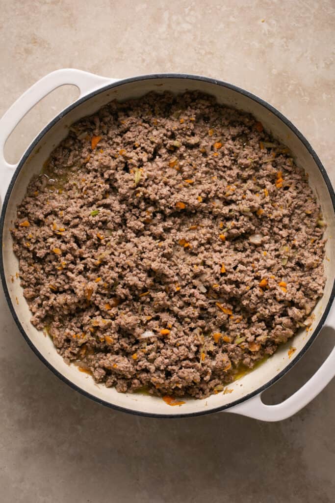 Cooked ground beef and veggies in a skillet.