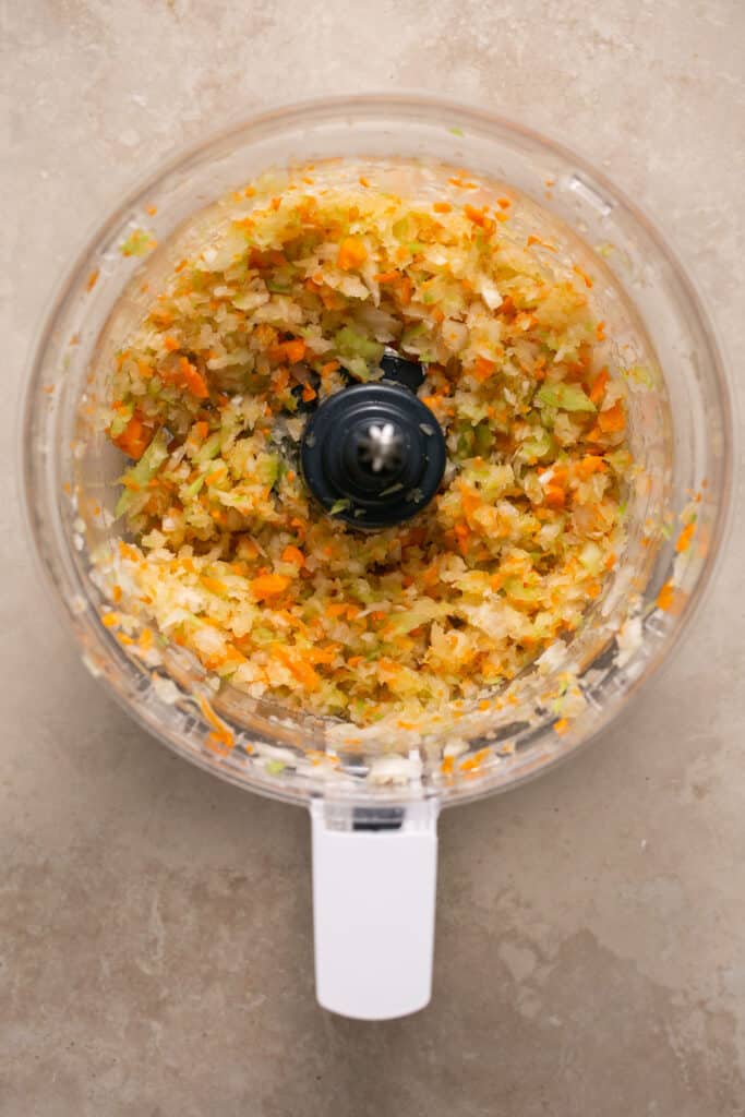 Chopped veggies in a food processor aftering being processed.