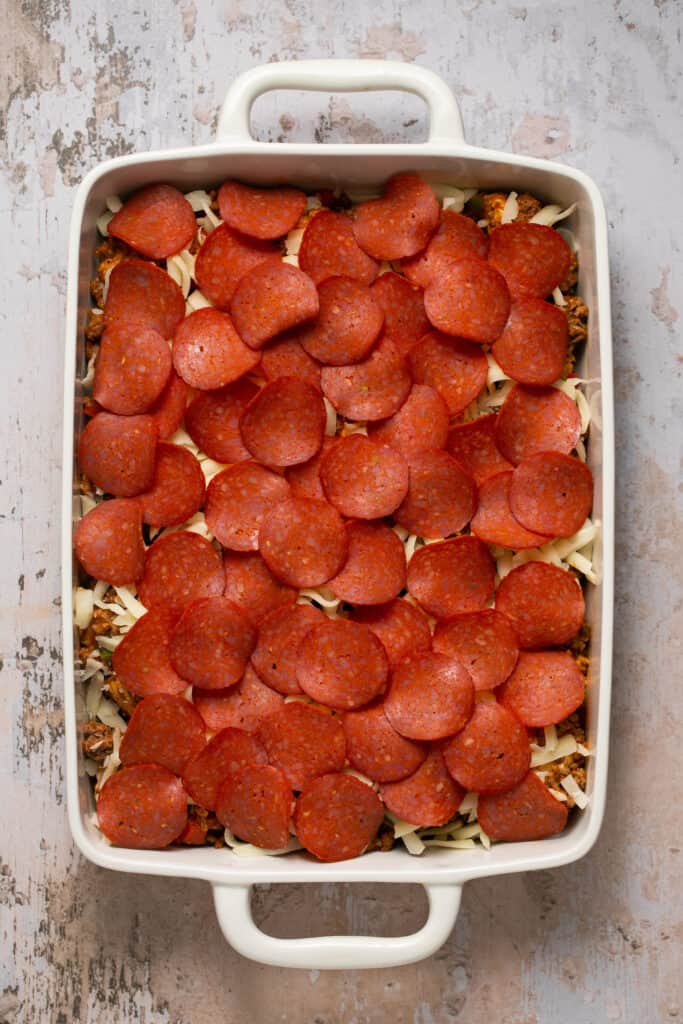 Pizza casserole with biscuits in a baking dish before being baked.