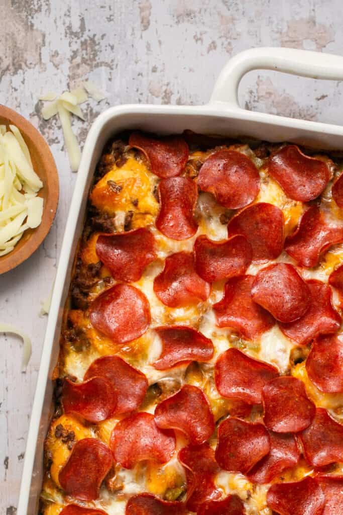 Pizza casserole with biscuits in a baking dish.