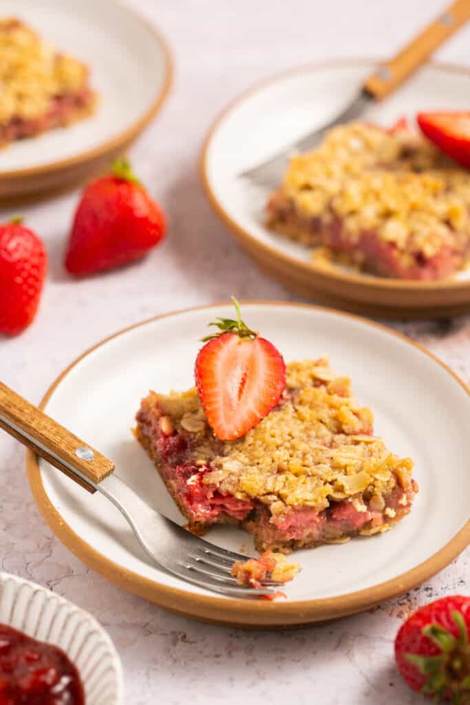 Healthy strawberry crumble bar on a plate with a fork.