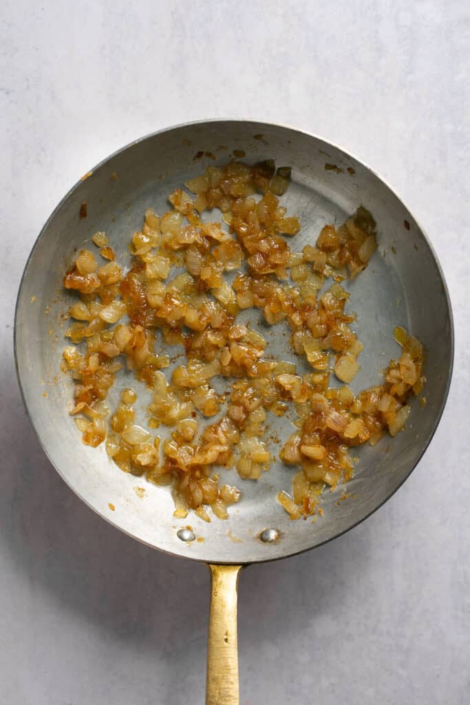 Browned chopped onion in a skillet.