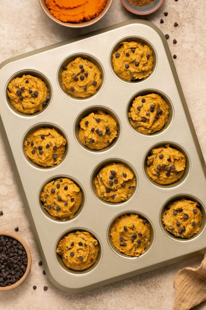 Healthy chocolate chip pumpkin muffins in a muffin pan before being baked.