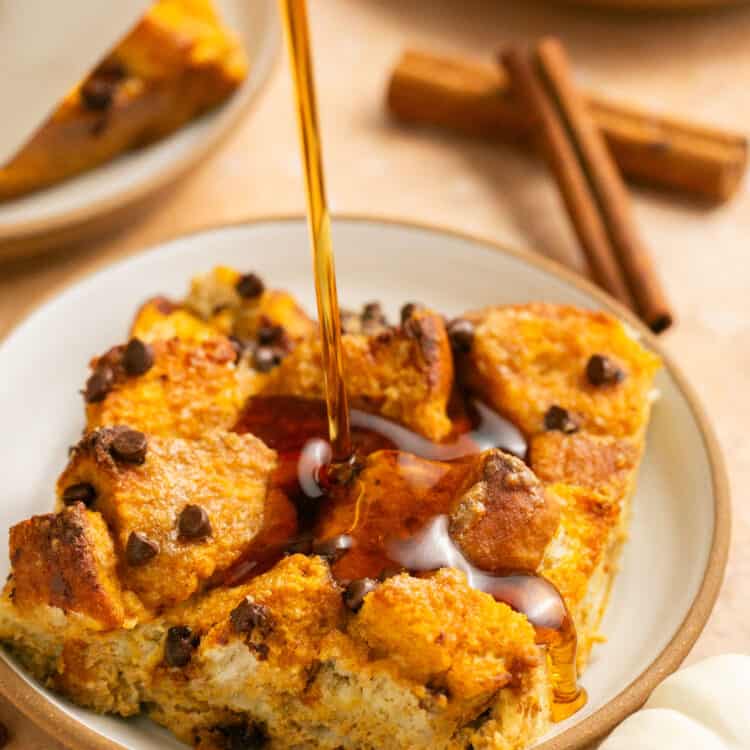 Pumpkin chocolate chip protein french toast bake on a small plate being drizzled with maple syrup.
