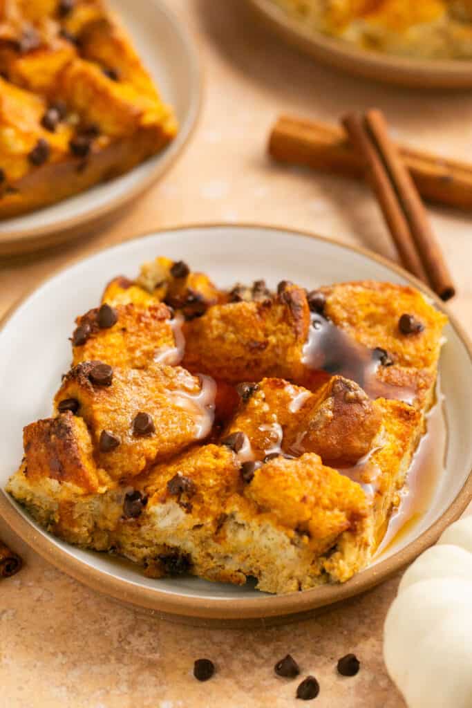 Pumpkin chocolate chip protein french toast bake on a small plate topped with maple syrup.