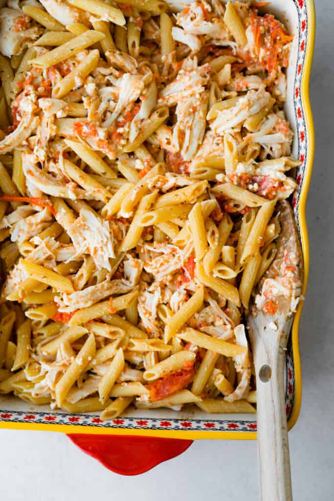 Baked tomato and feta chicken pasta in a baking dish.