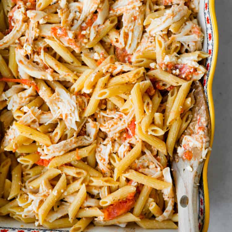 Baked tomato and feta chicken pasta in a baking dish.