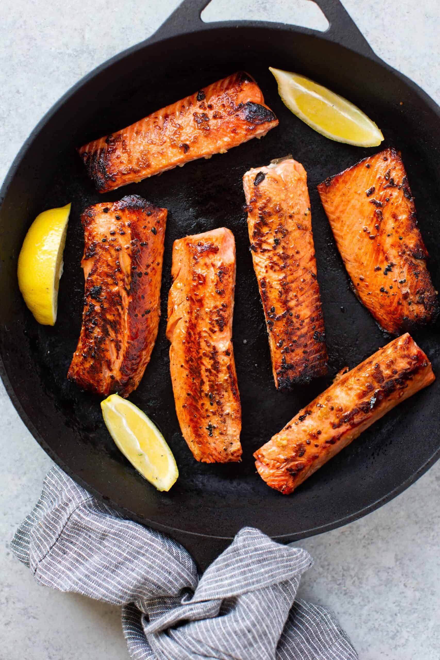 Honey garlic salmon recipe with lemon spices in a skillet.