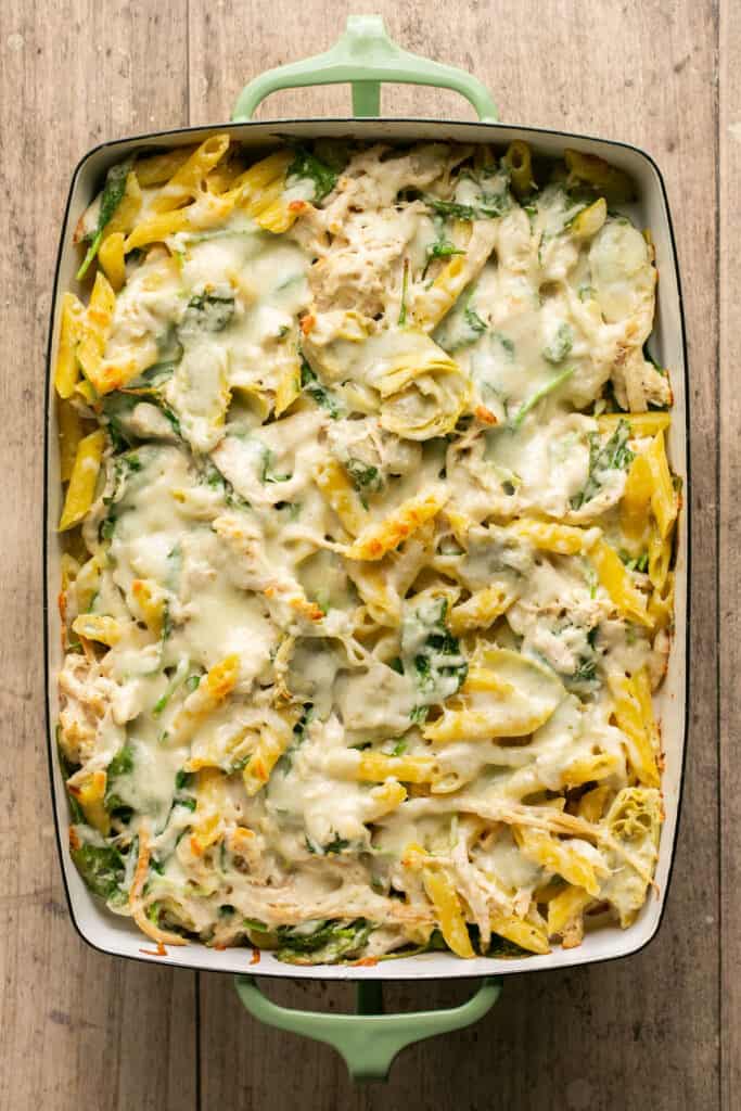 Healthy spinach and artichoke pasta bakein a baking dish after being baked.