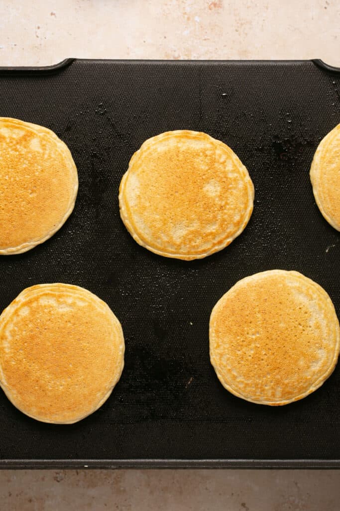 Golden pancakes on a griddle.
