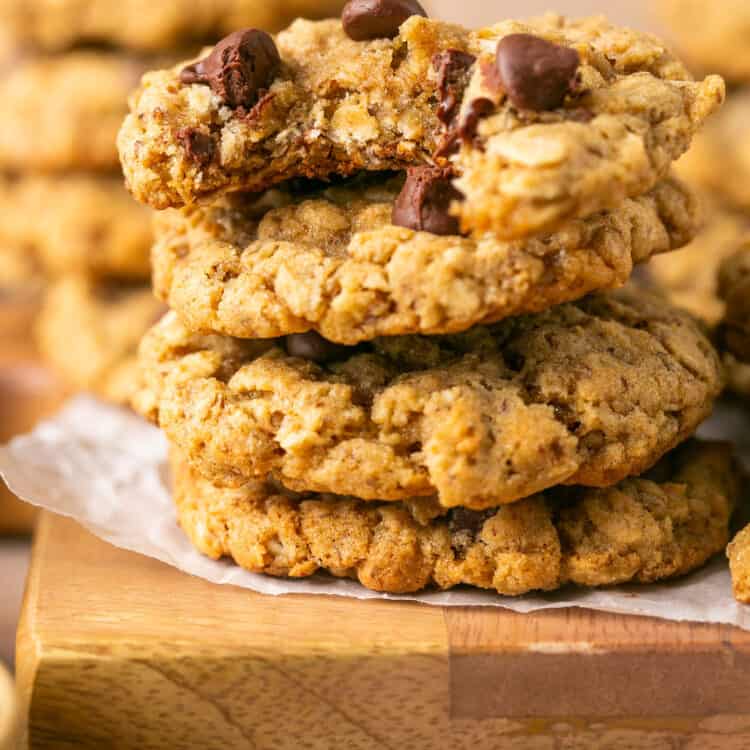 Oatmeal Chocolate Chip Lactation Cookies (Without Brewer's Yeast) stacked on top of each other on a cutting board with parchment paper.