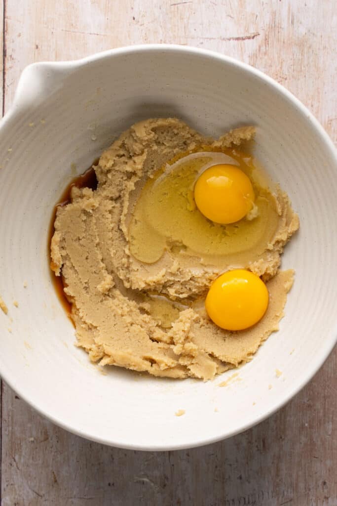 Two eggs added to the ingredients in a mixing bowl.