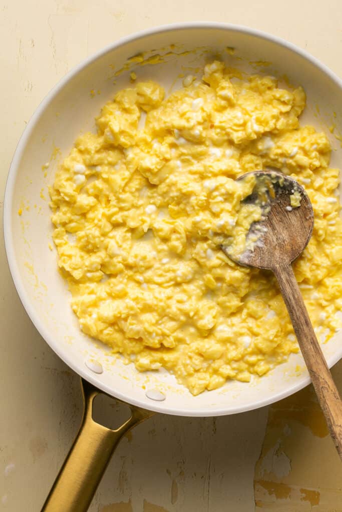 Scrambled eggs with cottage cheese in a skillet.