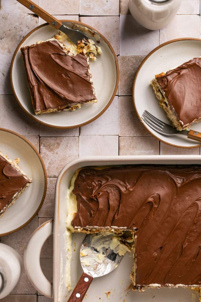 Lightened up chocolate eclair cake in a baking dish being served on small plates.