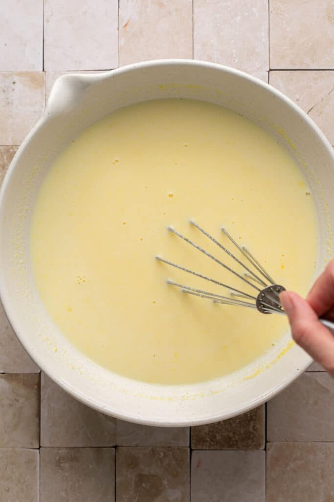 Pudding mix and milk in a bowl with whisk.