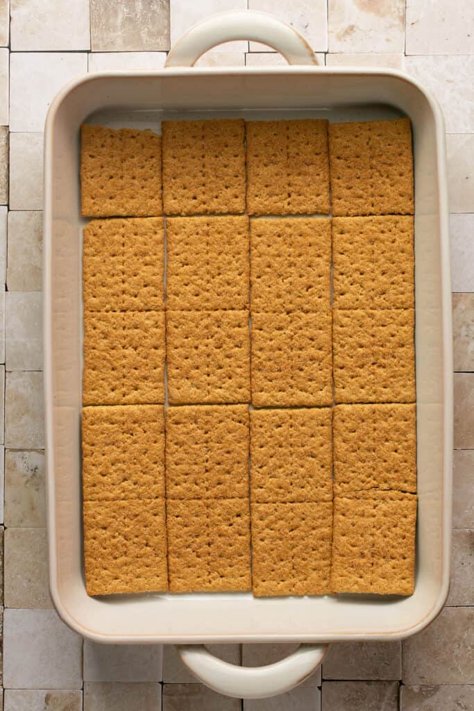 Single layer of graham crackers arranged on the bottom of a rectangle baking dish.