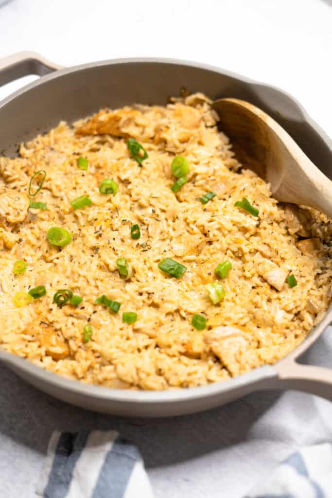 Creamy parmesan rice and chicken in a skillet.