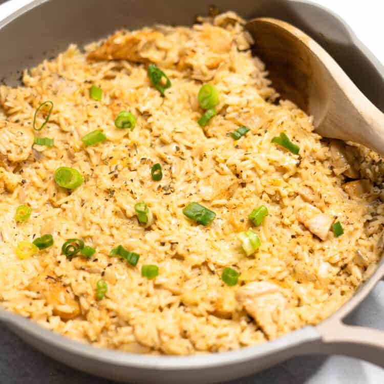 Creamy parmesan rice and chicken in a skillet.