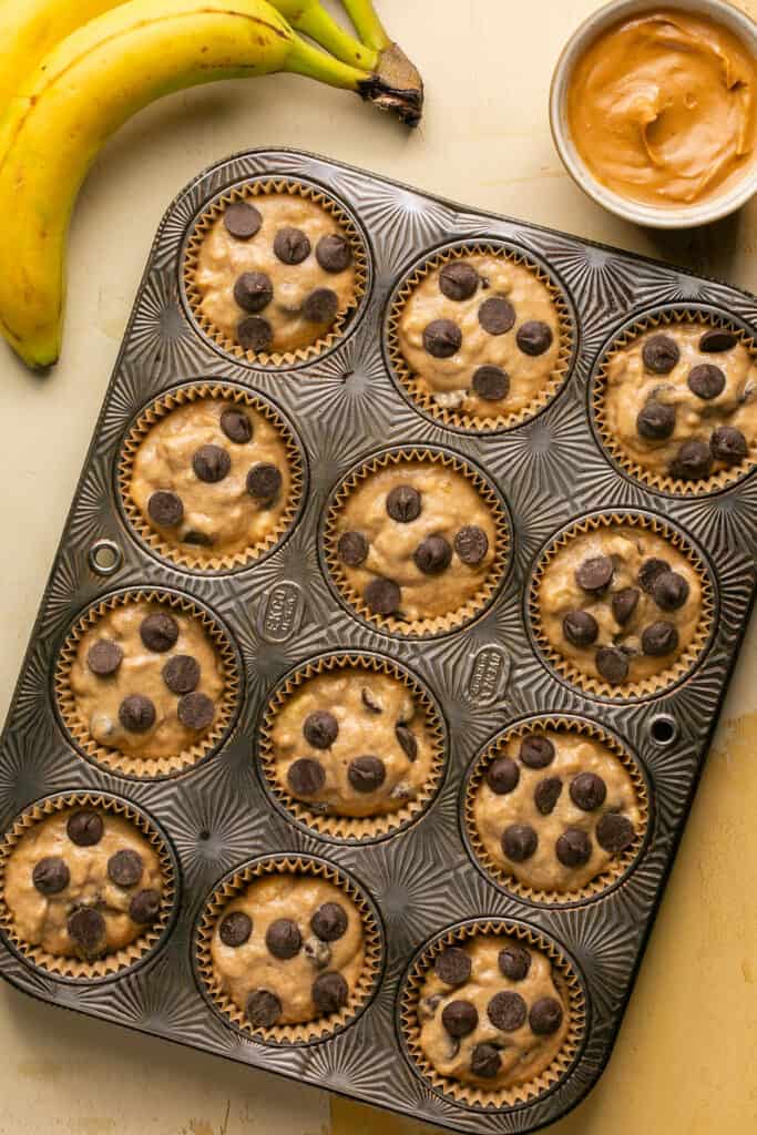 Peanut butter banana oat flour muffins in a muffin pan before being baked.