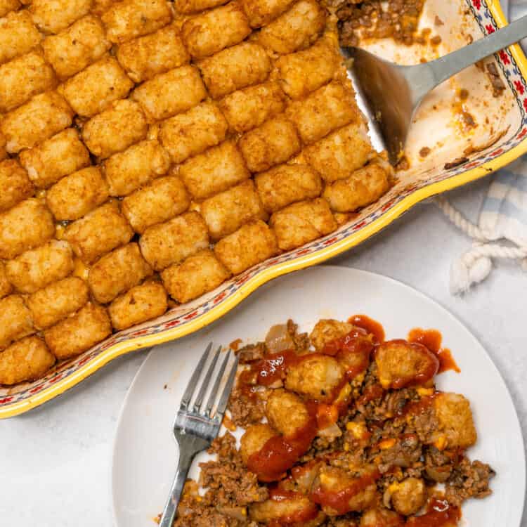 Healthier tater tot casserole on plate with a fork and in a casserole dish.