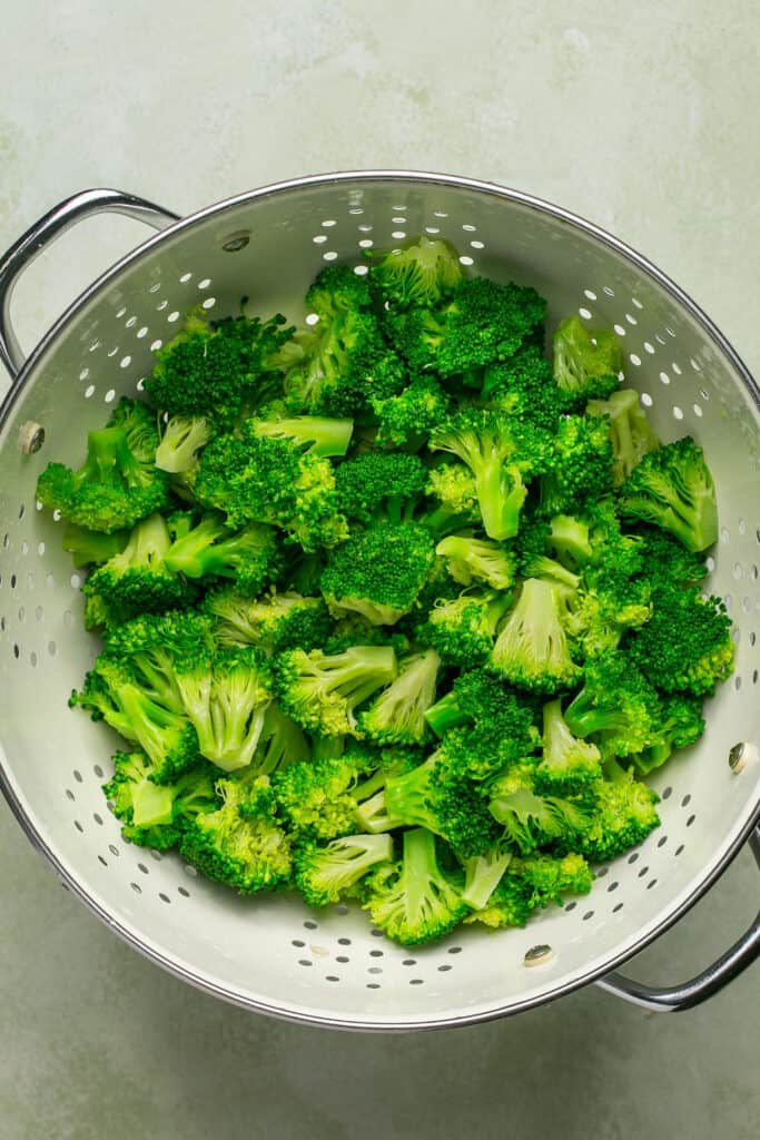 Chopped broccoli in a colander.