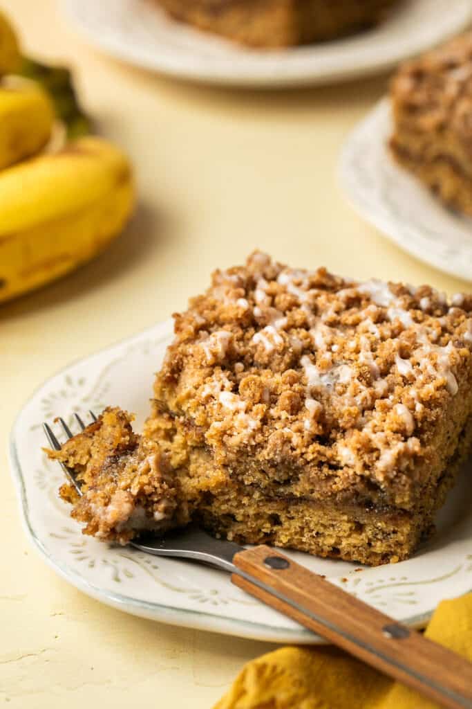 Banana sour cream coffee cake on a small plate with a fork.