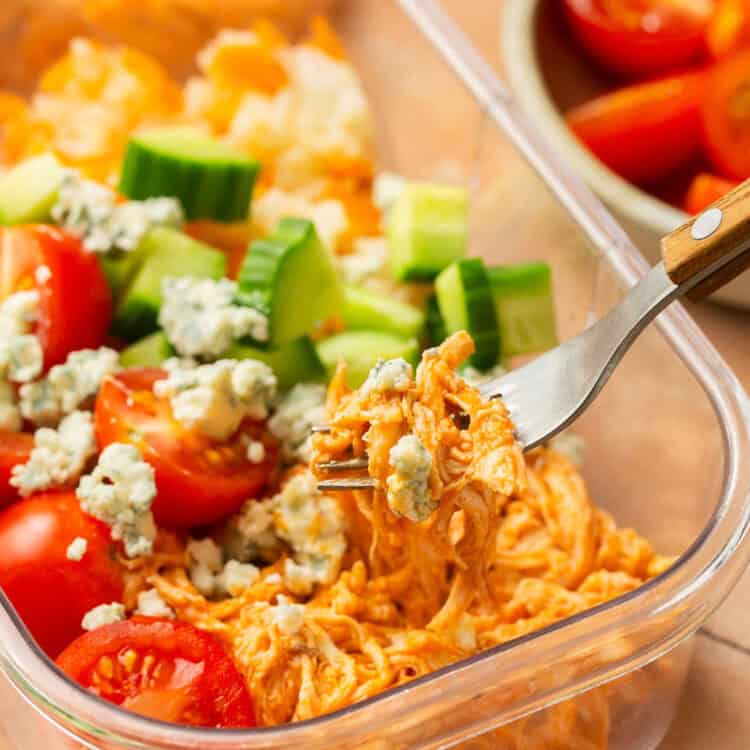 Zoomed in view of buffalo chicken rice bowl with a meal prep container.