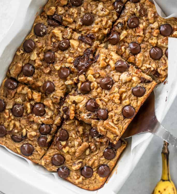 Chunky monkey banana baked oatmeal in a baking dish cut into squares.