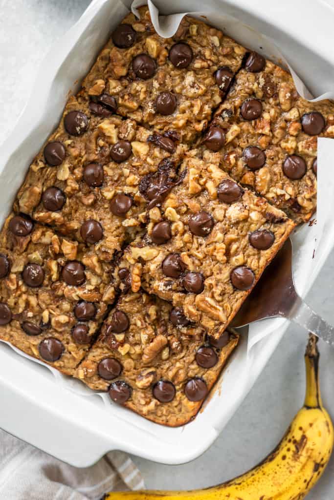 Chunky monkey banana baked oatmeal in a baking dish cut into squares.