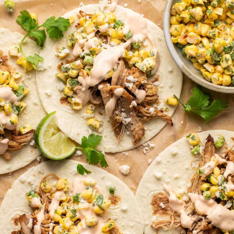 Mexican street corn carnitas tacos, open faced, topped with Mexican Crema.