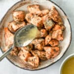 Lemon butter salmon bites in a bowl with a spoon.
