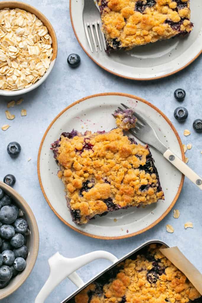 Blueberry muffin baked oatmeal on small plates with forks.