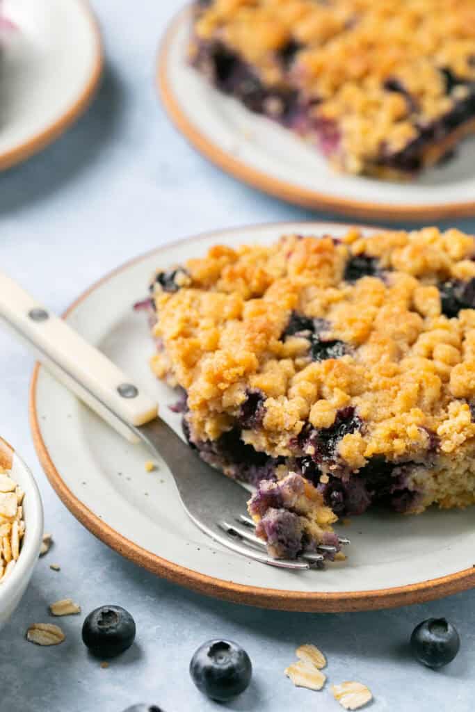 Blueberry muffin baked oatmeal on a small plate with a fork.