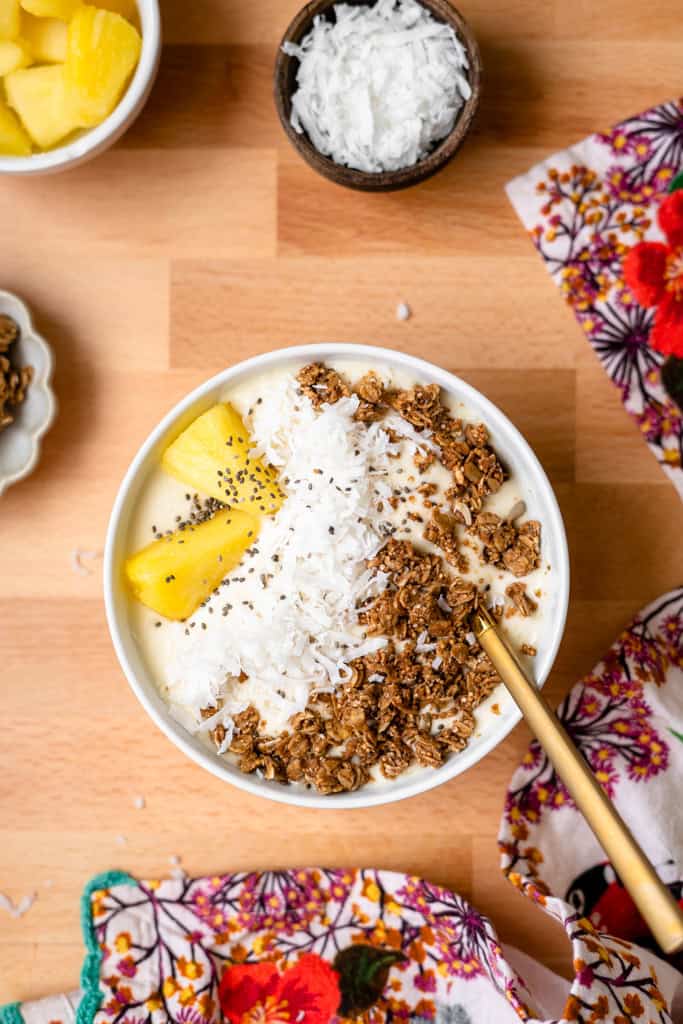 Pina colada smoothie bowl topped with pineapple, coconut, and granola.