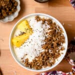 Pina colada smoothie bowl topped with pineapple, coconut, and granola.