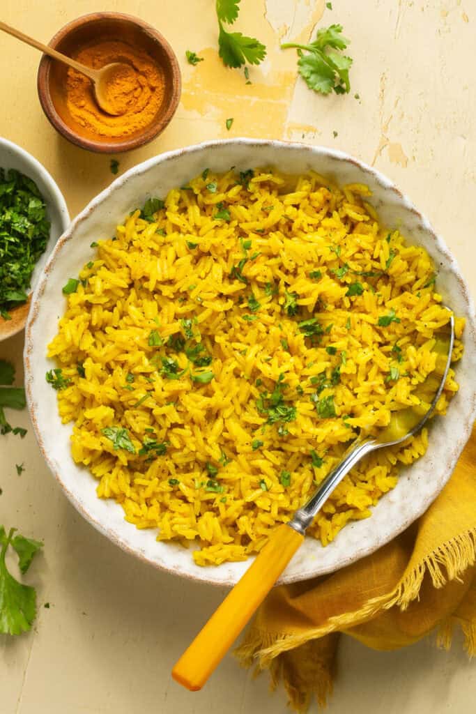 Instant pot yellow rice in a bowl with a spoon.