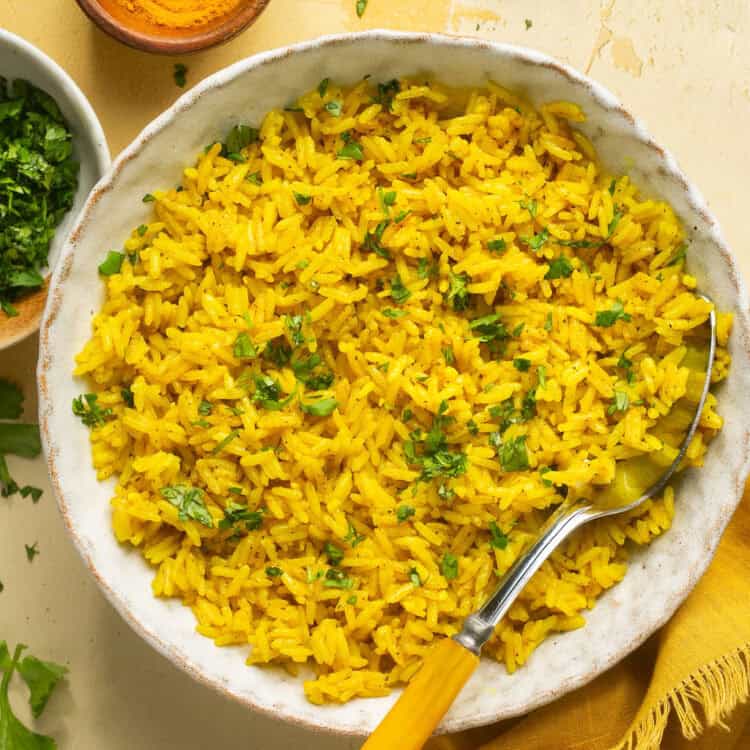 Instant pot yellow rice in a bowl with a spoon.