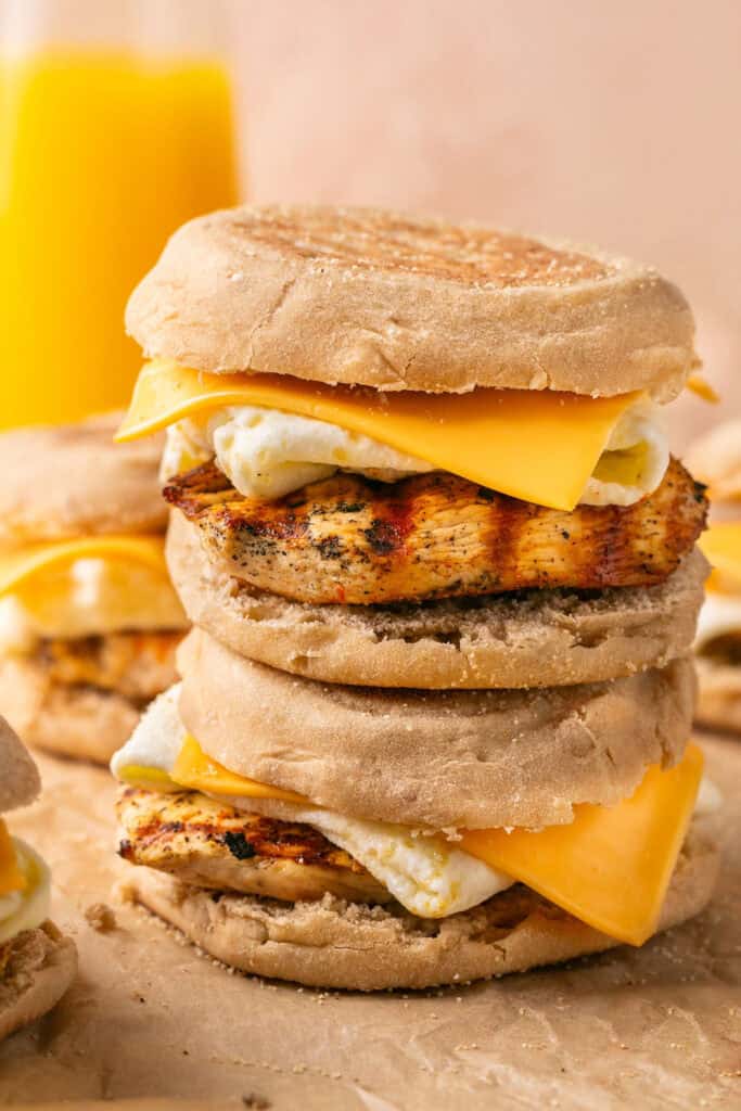 Egg white grills sandwiches stacked on top of each other on parchment paper.