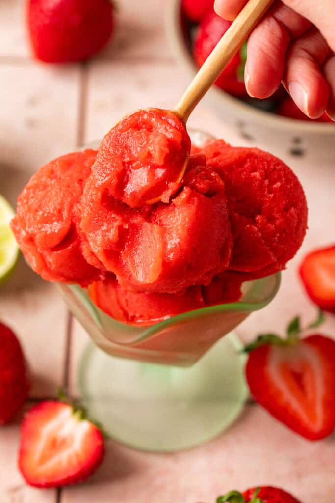 Ninja creami strawberry sorbet in an ice cream dish with a spoon.