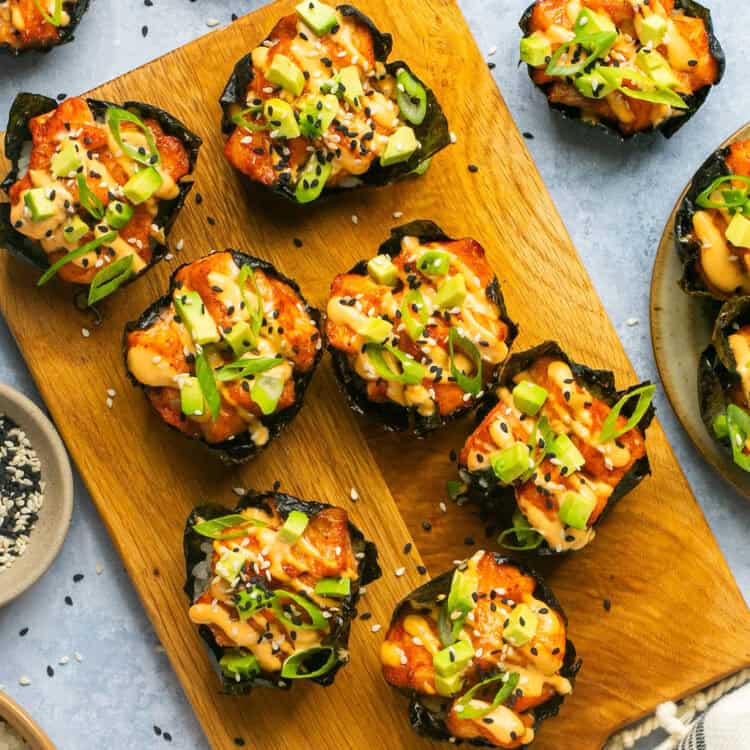 Baked salmon sushi cups on a cutting board.